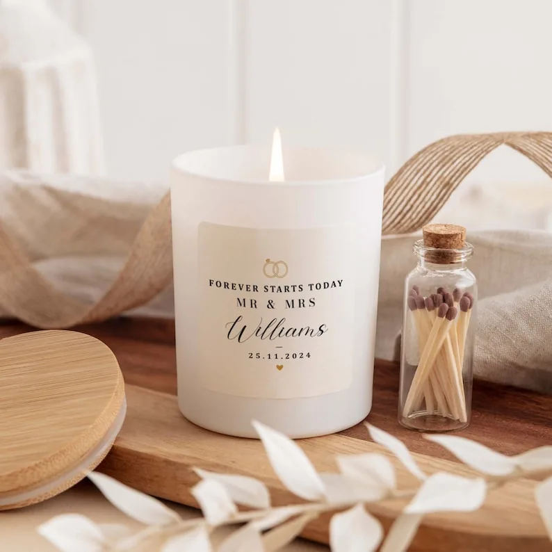 A personalized white wedding candle with a wooden lid and small bottle of matches
