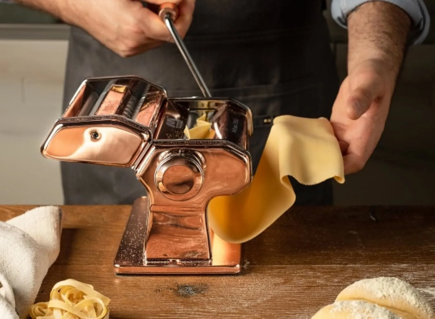 Hands rolling fresh pasta through a Marcato Atlas 150